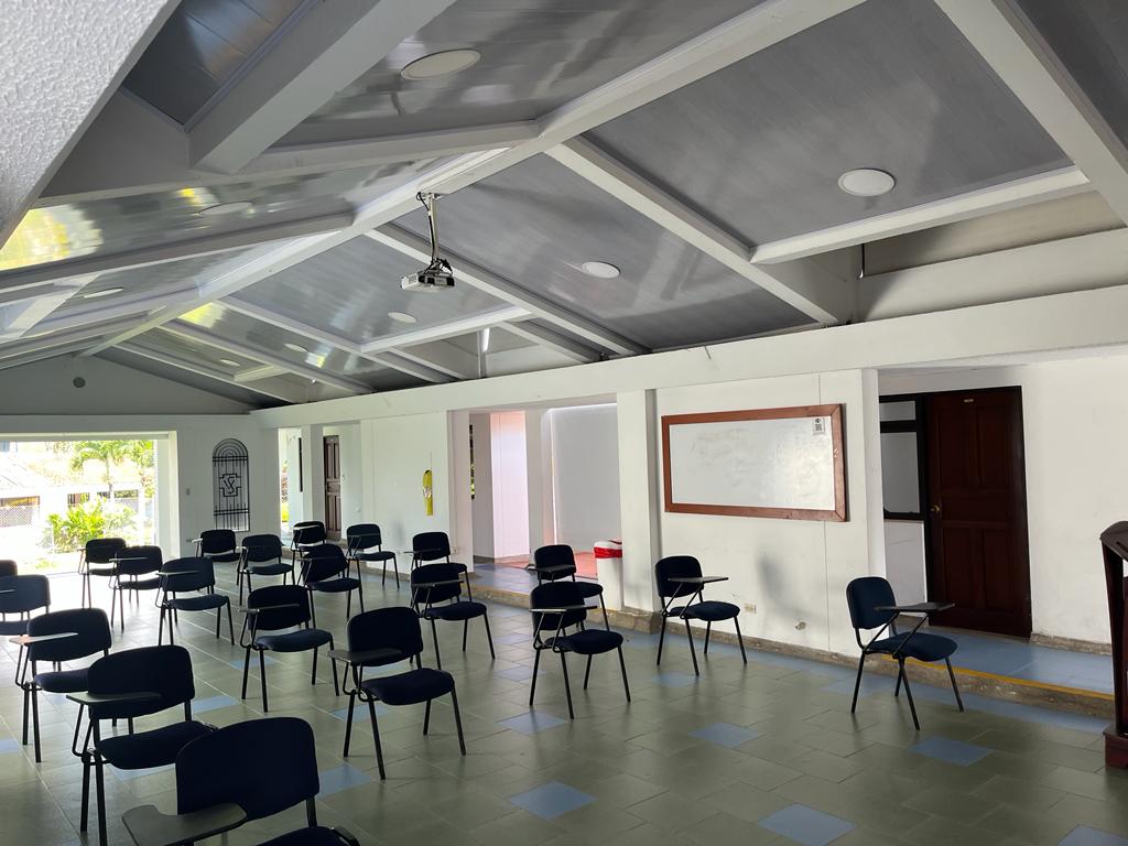 Sillas con apoyabrazos y tablero en un salón de formación de la Casa Buenos Aires